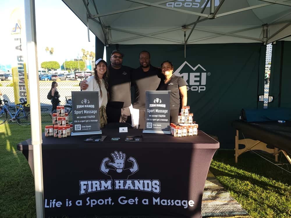 The Firm Hands booth at an outdoor expo with the team behind the table