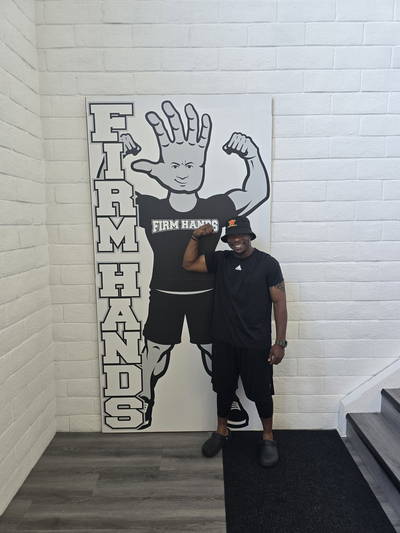 A visitor in a bucket hat flexing beside the Bruce board