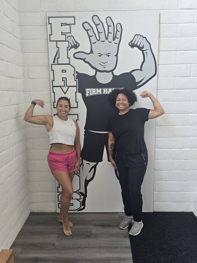 Two visitors flexing together beside the Bruce board